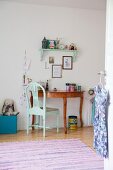 Turquoise chair in front of semi-circular desk in child's bedroom