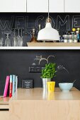 Küchentheke mit schwarzer Tafel als Spritzschutz und weißem Wandboard