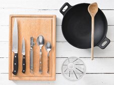 A wok with assorted kitchen utensils