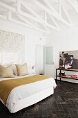 White-painted roof beams in retro bedroom