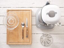 Utensils for preparing juice: a blender, measuring cup, citrus press and cutlery