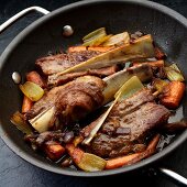 Braised beef ribs with carrots, celery and onions