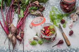 Rote Bete, eingelegt und frisch, auf Gartentisch