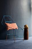 Delicate metal chair with leopard-print cushion against dark wall