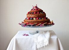 A naked birthday cake with fresh figs and berries