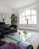 Leather couch and glass table in lounge area of renovated period apartment