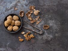 Whole walnuts, nut shells, a nutcracker and walnut seeds