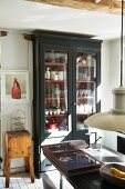 Crockery in glass-fronted cabinet in vintage interior