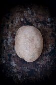 A potato on a dark surface (seen from above)