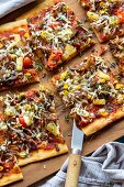 A pizza with pulled pork, sweetcorn, pineapple and onions