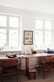 Subtle Christmas decorations in lattice windows of period apartment above long rustic wooden table