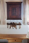 Old wall-mounted cabinet above wooden spoons in rack