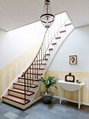 Steep staircase and dado painted in yellow stripes in foyer