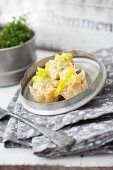 Chicken salad with celery and sweetcorn served in pastry bowls on a tin plate