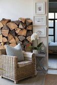 Wicker armchair in front of rustic stack of firewood in living area