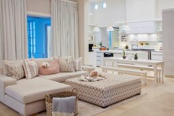 Offener Wohnraum in Weiß mit Sofa, Esstisch und Küche