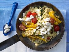 Millet and vegetable pan with cherry tomatoes and sheep's cheese