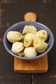 Artichoke hearts in a bowl on a chopping board