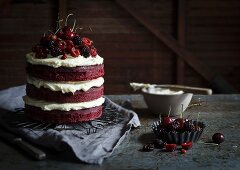 A red velvet cake with berries and cherries