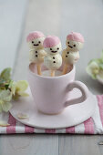 Stollen cake pop snowmen covered in white chocolate and presented in a cup of sugar