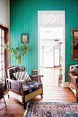 Old armchair in front of turquoise painted wall with passage