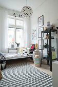 Black and white rug, display cabinet and action figures in boy's bedroom in period apartment