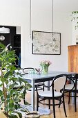 Spring flowers on pale grey wooden table and black bentwood chairs