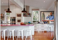 Pink kitchen countertop on kitchen counter with bar stool in open kitchen with retro flair