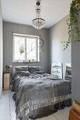 White board floor, chandelier and dreamcatcher in bedroom in shades of grey