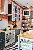 Küche im Industriestil mit Backsteinwand und Bücherregal