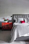Elegantes Schlafzimmer in Grautönen mit roten Farbakzenten