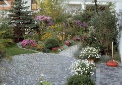 Small city garden with round paved terrace of granite stones