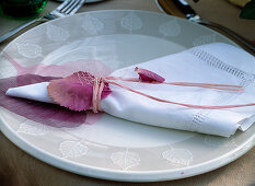 Tischdeko: Serviette mit Brassica (Zierkohlblätter) dekoriert
