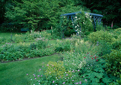 Beds with geranium (cranesbill), alchemilla mollis (lady's mantle), astilbe (ornamental lychnis), lychnis coronaria (coneflower), pavilion overgrown with Rosa 'Guirlande d'amour' (rambler rose), frequent flowering with good fragrance