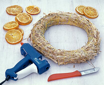 Sticking straw wreath with orange pieces (1/3)