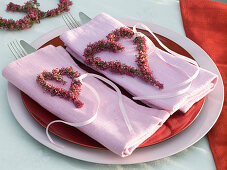 Hearts of Erica (bell heather) with ribbons on folded napkins