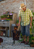 Lohas series: Man heating fire basket, in the background pot shelf