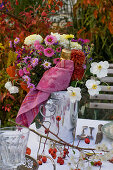 Set table in front of autumn bed: bouquet of anemone (autumn anemone)