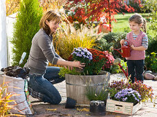 Mother and daughter planting wooden buckets