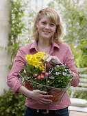 Young woman with freshly bought Primula elatior (spring primroses), Viola