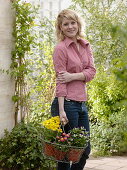 Young woman with freshly bought Primula elatior (spring primroses), Viola