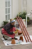 Bunt angemalte Tontöpfe auf Pfählen als Nützlings-Unterschlupf (3/13)