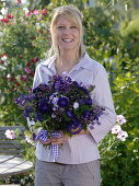 Young woman with bouquet of Callistephus (summer aster), Salvia horminium