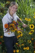 Junge Frau schneidet Blumen für Spätsommerstrauß