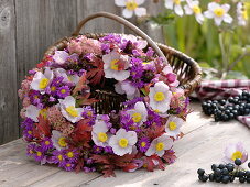 Wreath of autumn anemones, asters, sedum and beaked leaves