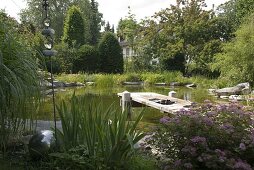 Swimming pond with wooden pier bordered with granite blocks