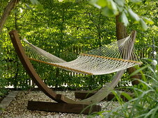 Hanging hammock with wooden frame on gravel