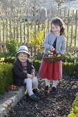 Kinder suchen Ostereier im Bauerngarten