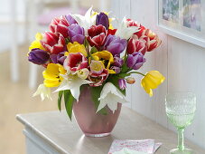 Tying a colourful tulip bouquet 