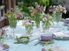 Small meadow flower bouquets in glasses